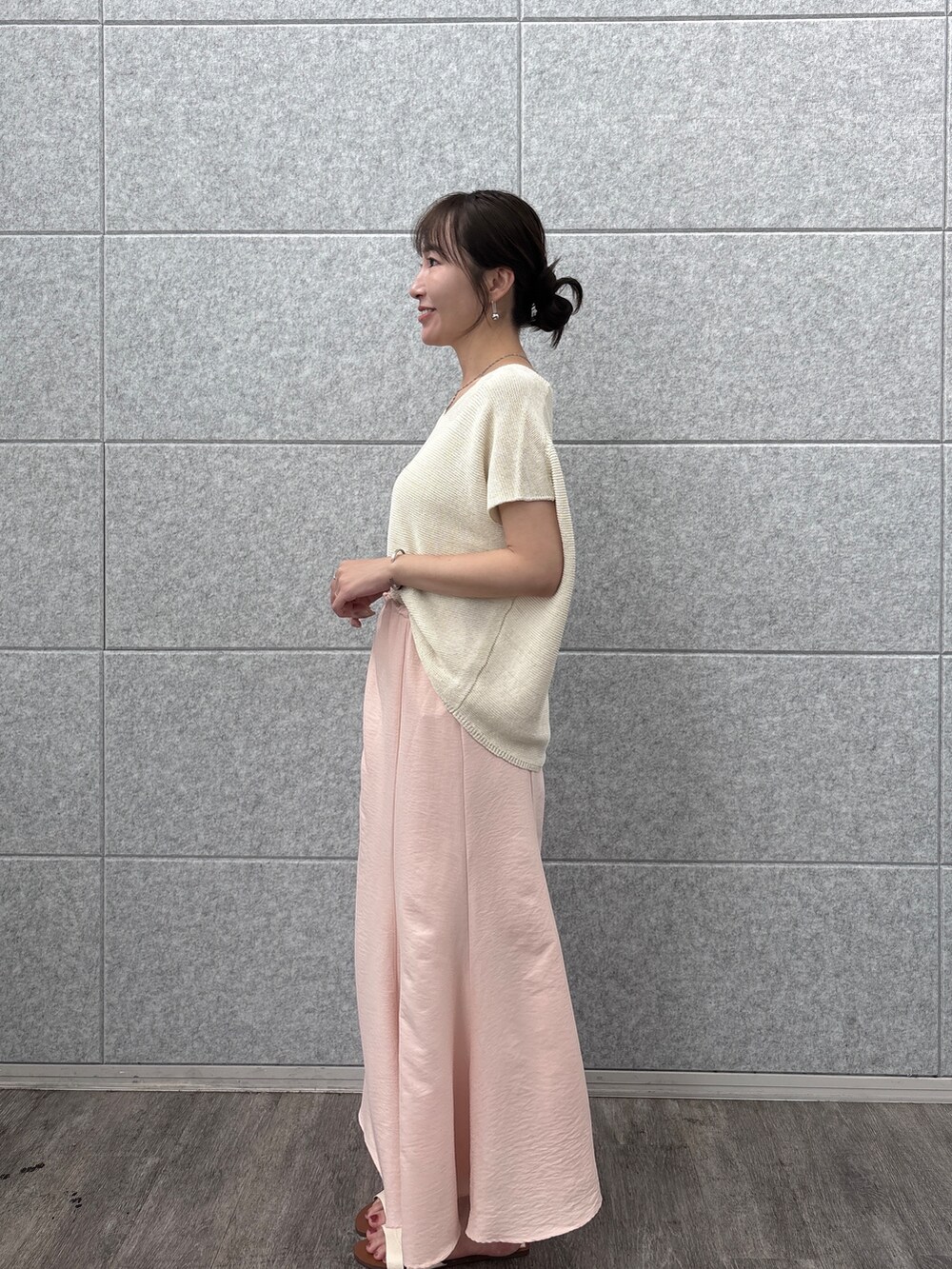 ベージュ系のニット/セーターを着用したレディースの夏コーディネートの2枚目の写真