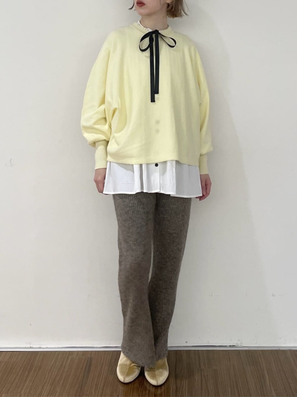 ホワイト系のシャツ/ブラウス、ブラウン系のその他パンツ、イエロー系のニット/セーターを着用したレディースの秋コーディネートの6枚目の写真