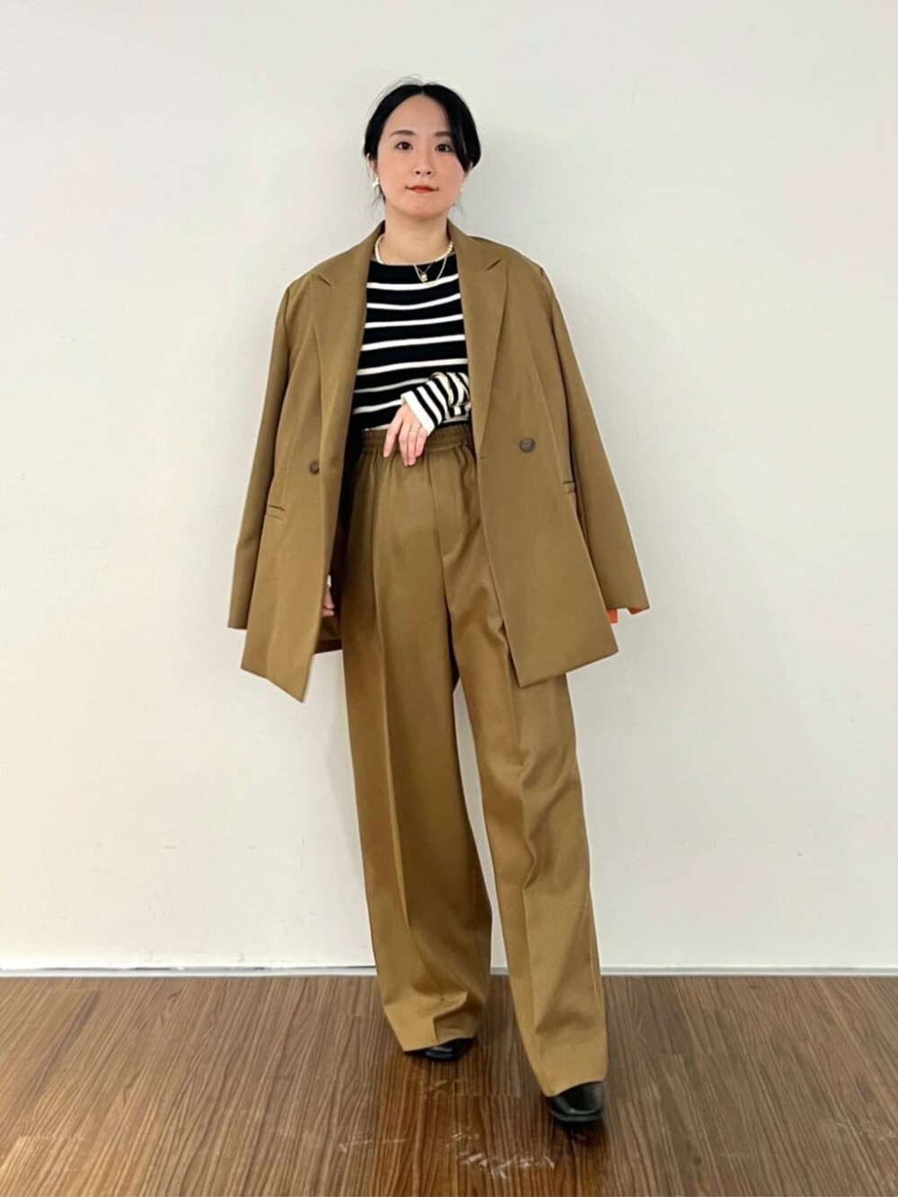 ブラック系のニット/セーター、イエロー系のその他パンツ、イエロー系のテーラードジャケットを着用したレディースの秋コーディネートの2枚目の写真