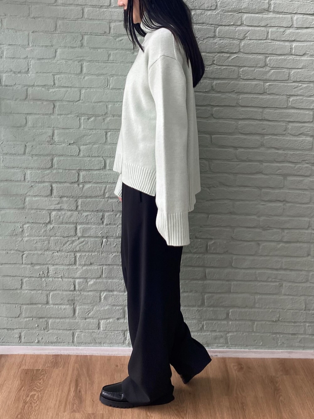 ブラック系のその他パンツ、グリーン系のニット/セーターを着用したレディースの秋コーディネートの3枚目の写真