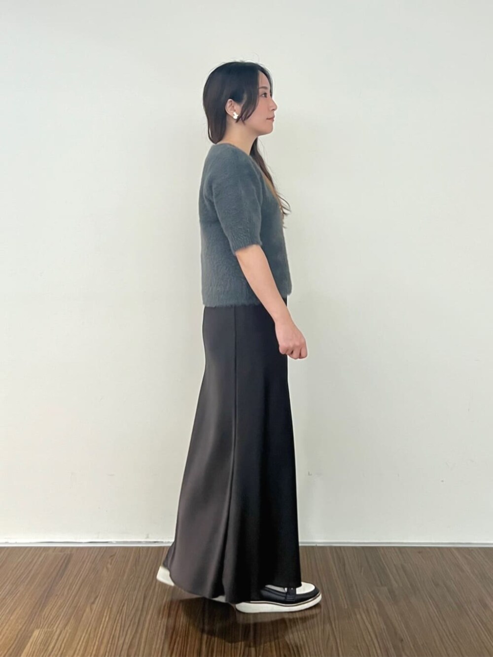 グレー系のニット/セーター、グレー系のスカートを着用したレディースの秋コーディネートの5枚目の写真