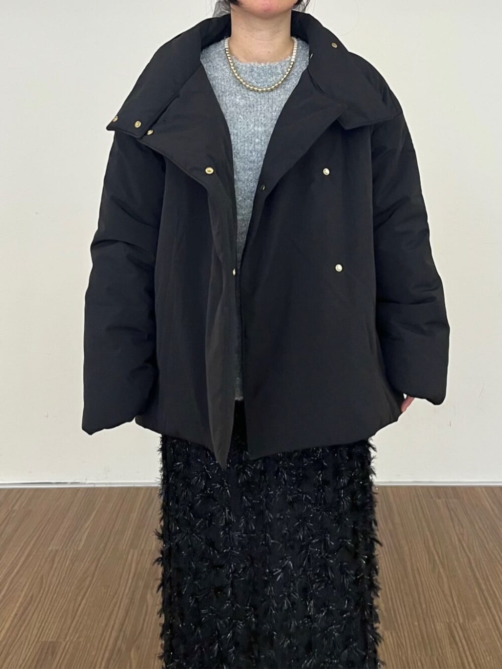 ブラック系のスカート、ブラック系のその他アウター、グレー系のニット/セーターを着用したレディースの冬コーディネートの4枚目の写真