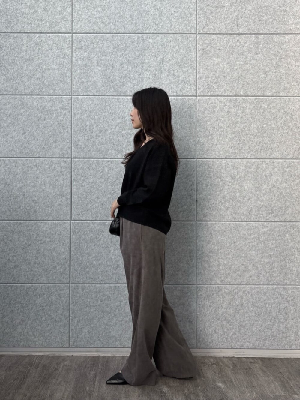 グレー系のその他パンツ、ブラック系のニット/セーターを着用したレディースの秋コーディネートの3枚目の写真