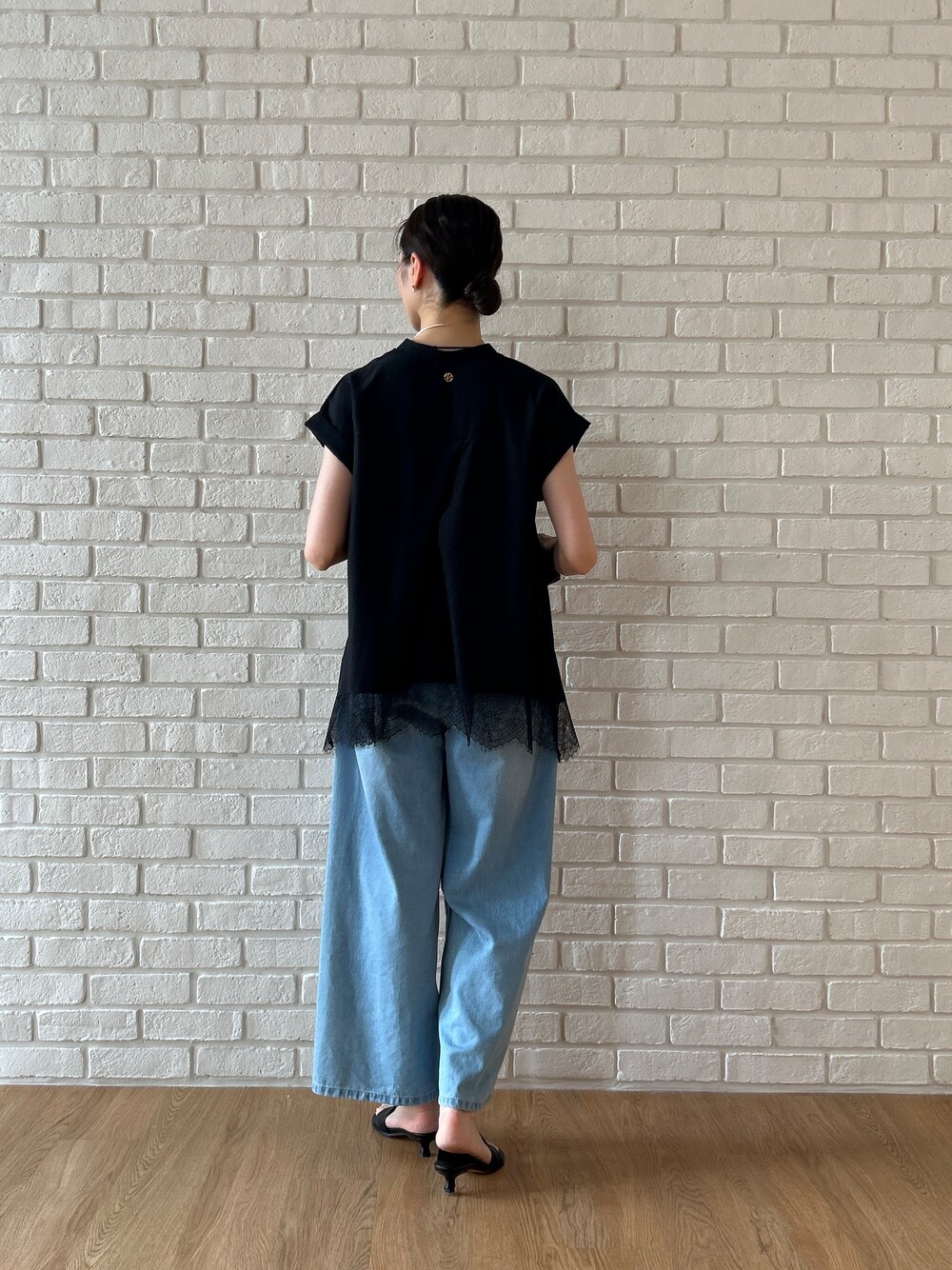 ブラック系のシャツ/ブラウス、ブルー系のデニムパンツを着用したレディースの春コーディネートの5枚目の写真