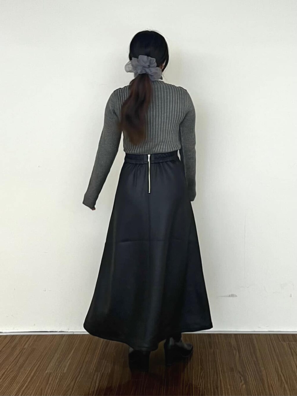 ブラック系のスカート、グレー系のニット/セーターを着用したレディースの冬コーディネートの4枚目の写真