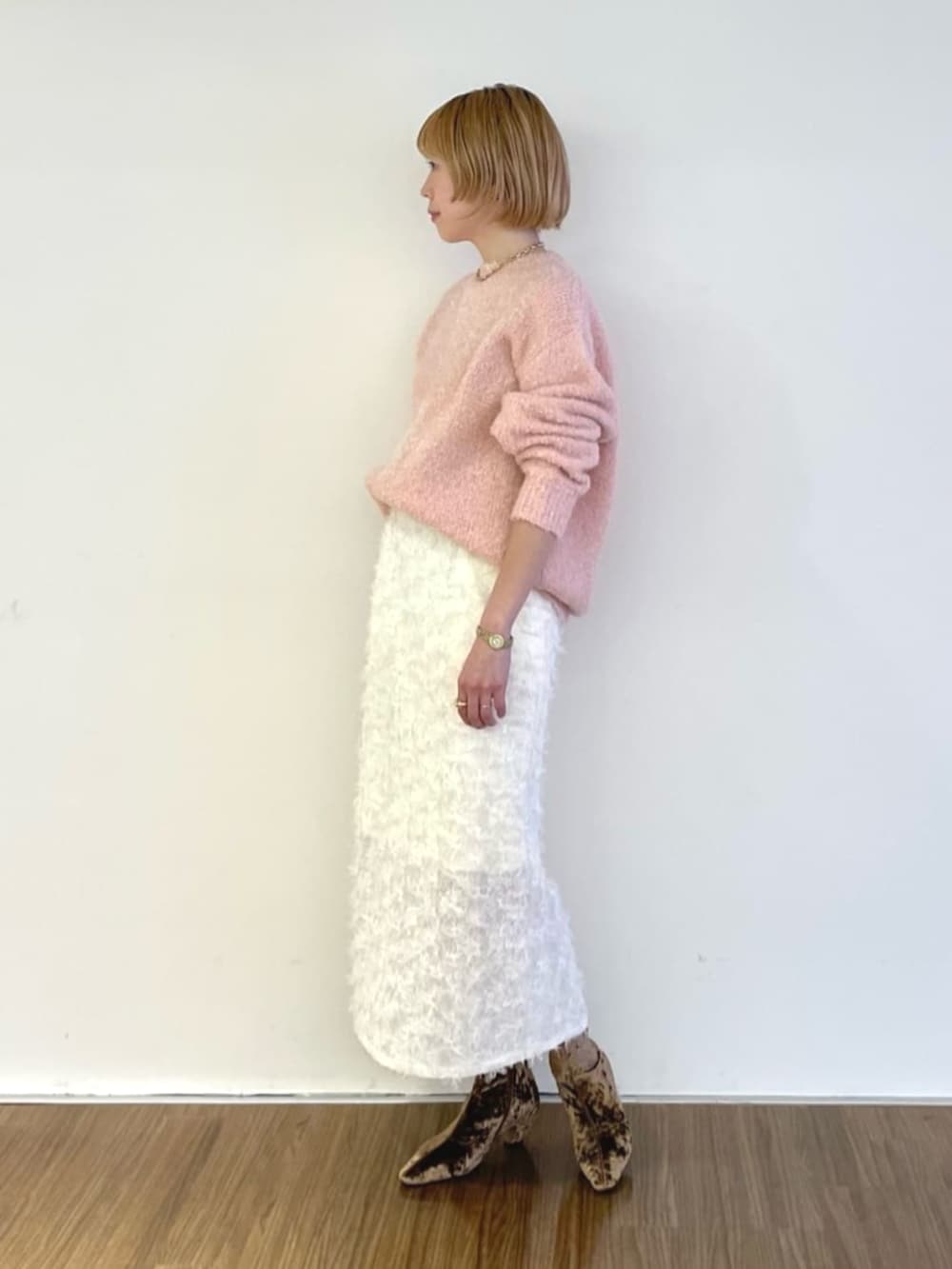 ホワイト系のスカート、ピンク系のニット/セーターを着用したレディースの冬コーディネートの2枚目の写真