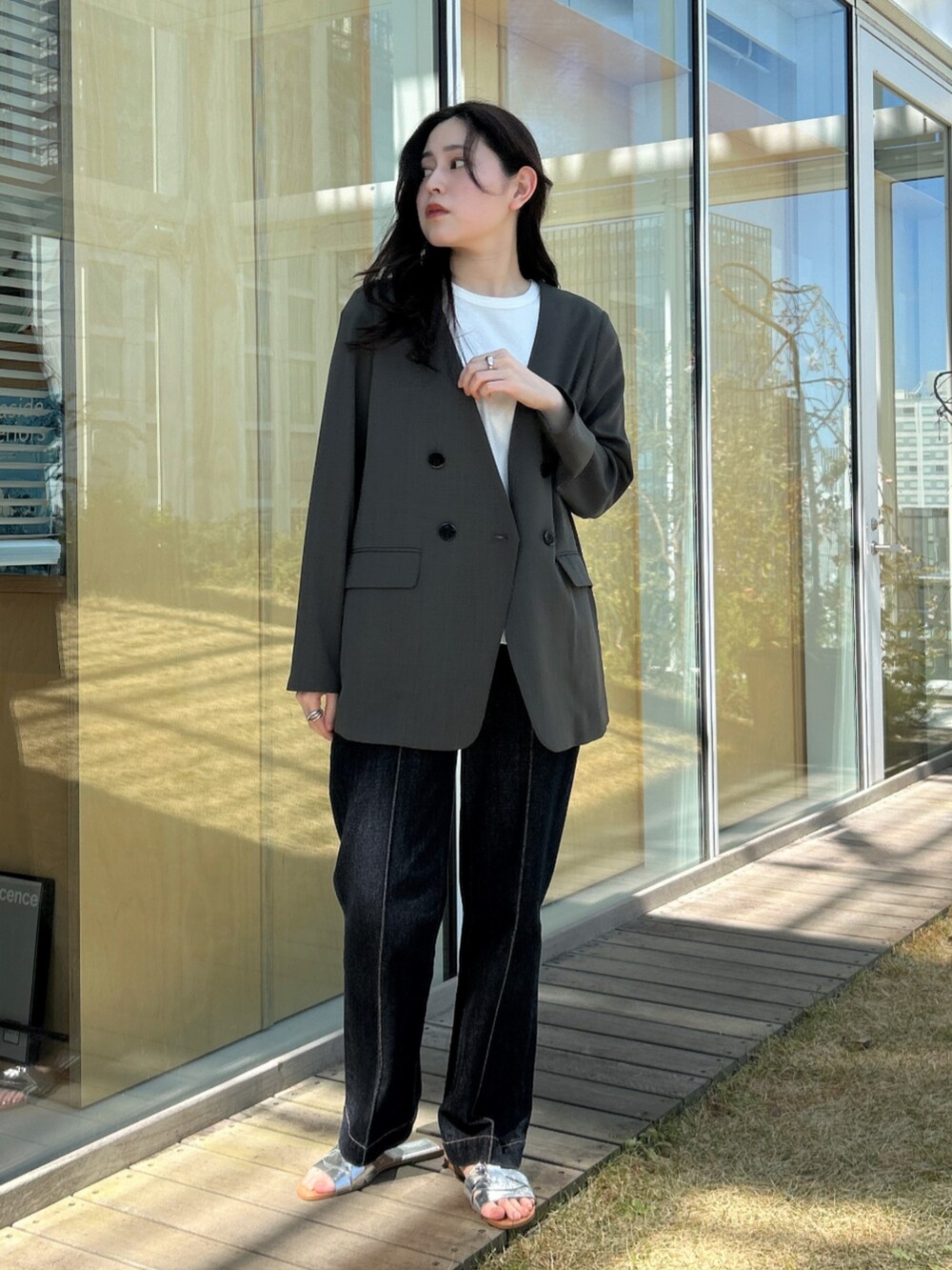ブルー系のデニムパンツ、グレー系のノーカラージャケットを着用したレディースの春コーディネートの3枚目の写真