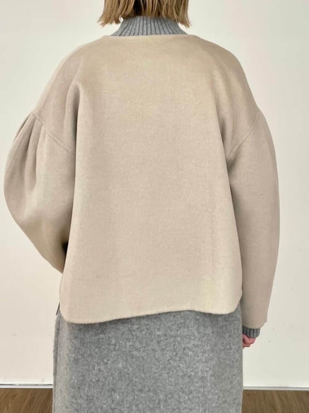 グレー系のワンピース、ベージュ系のノーカラーコートを着用したレディースの秋コーディネートの7枚目の写真