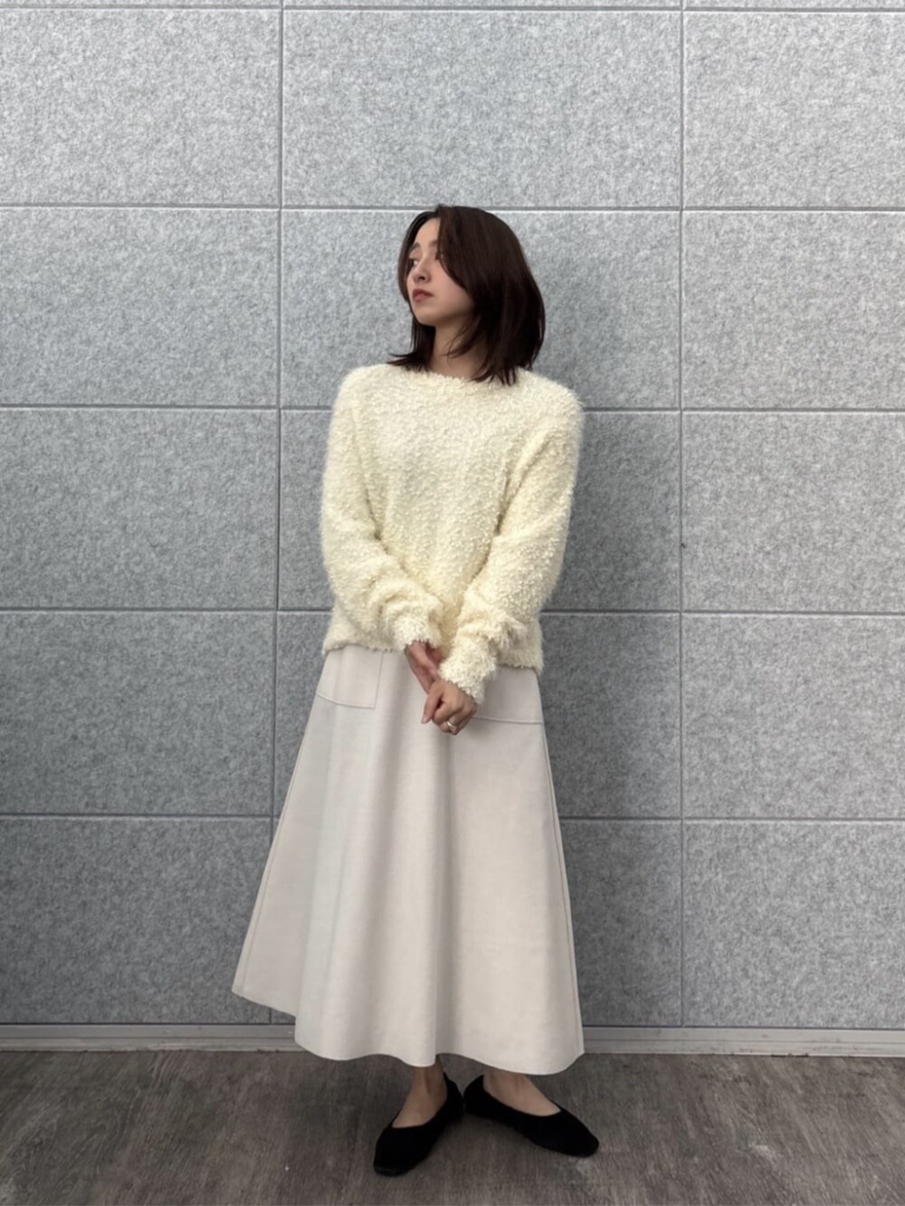 ホワイト系のニット/セーター、ホワイト系のスカートを着用したレディースの冬コーディネートの6枚目の写真