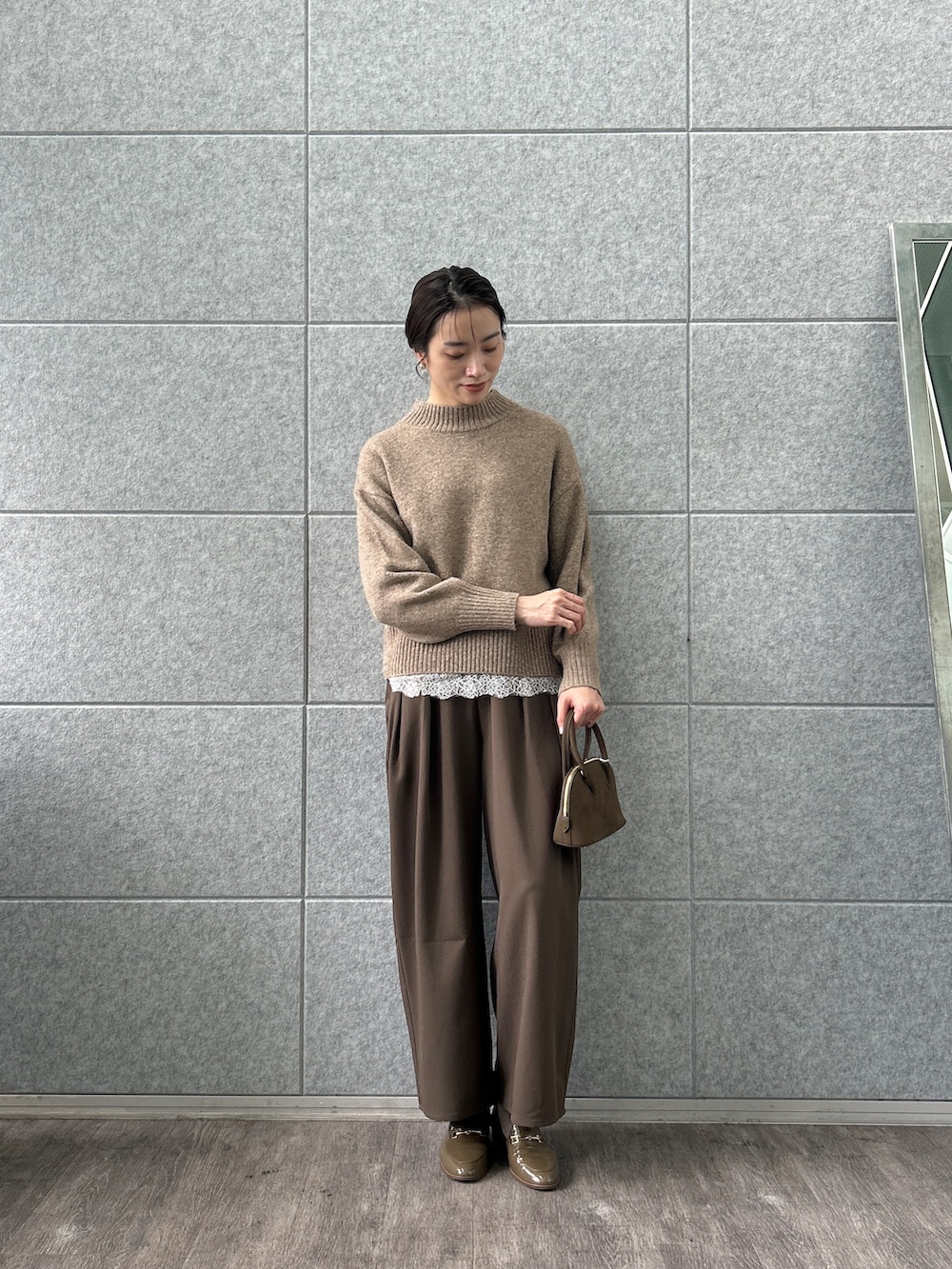 ホワイト系のシャツ/ブラウス、ベージュ系のニット/セーター、ブラウン系のその他パンツを着用したレディースの秋コーディネートの2枚目の写真