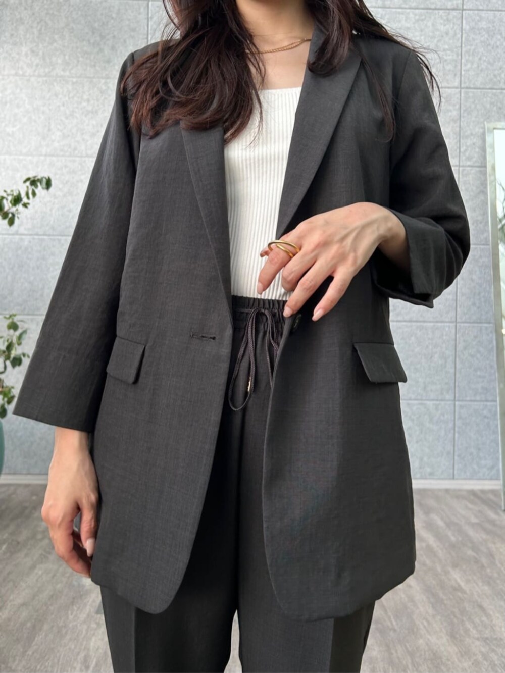 ホワイト系のタンクトップ、ブラック系のテーラードジャケット、ブラック系のその他パンツを着用したレディースの夏コーディネートの5枚目の写真