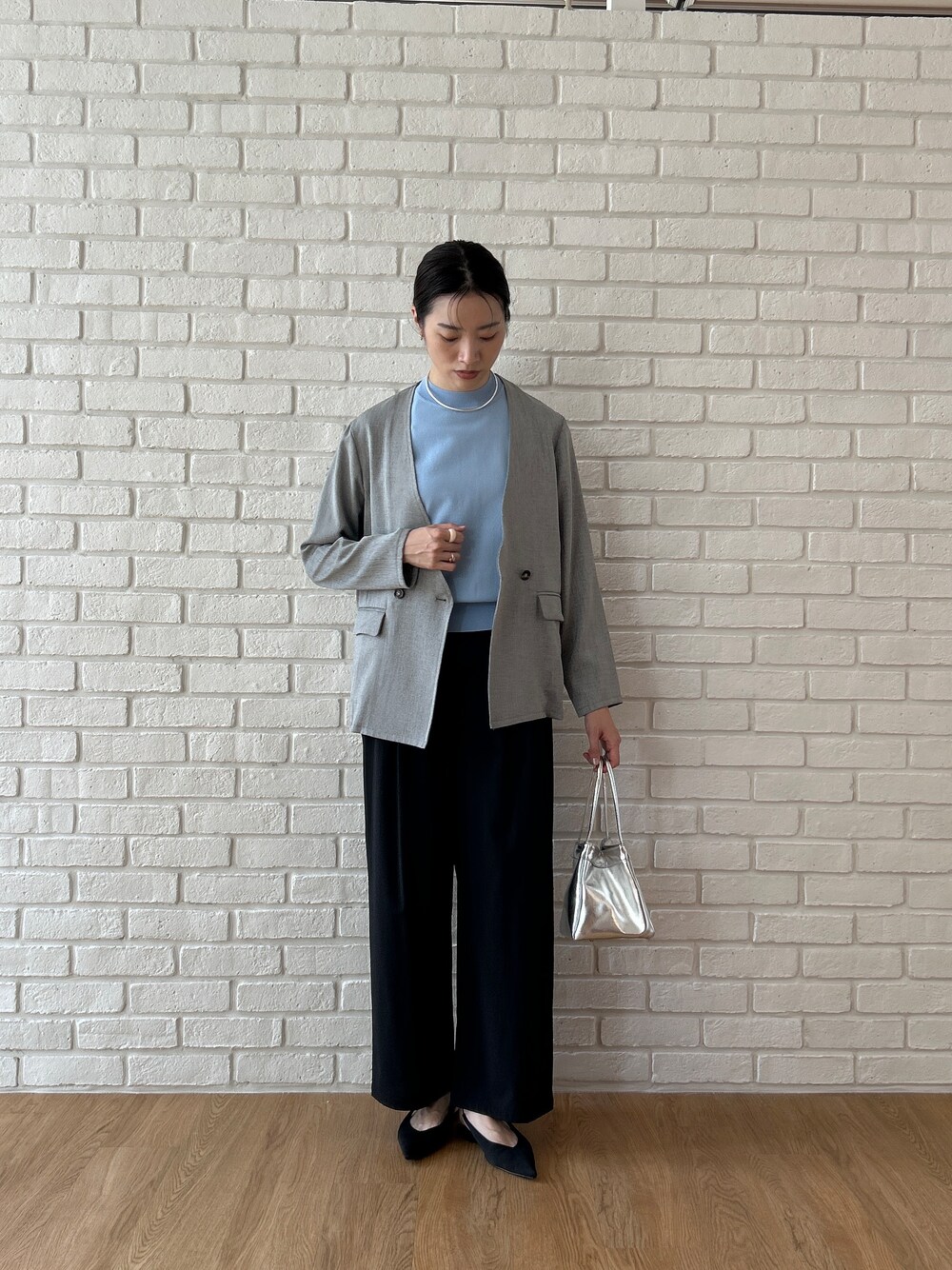 ブルー系のニット/セーター、グレー系のノーカラージャケット、ブラック系のその他パンツを着用したレディースの春コーディネートの6枚目の写真