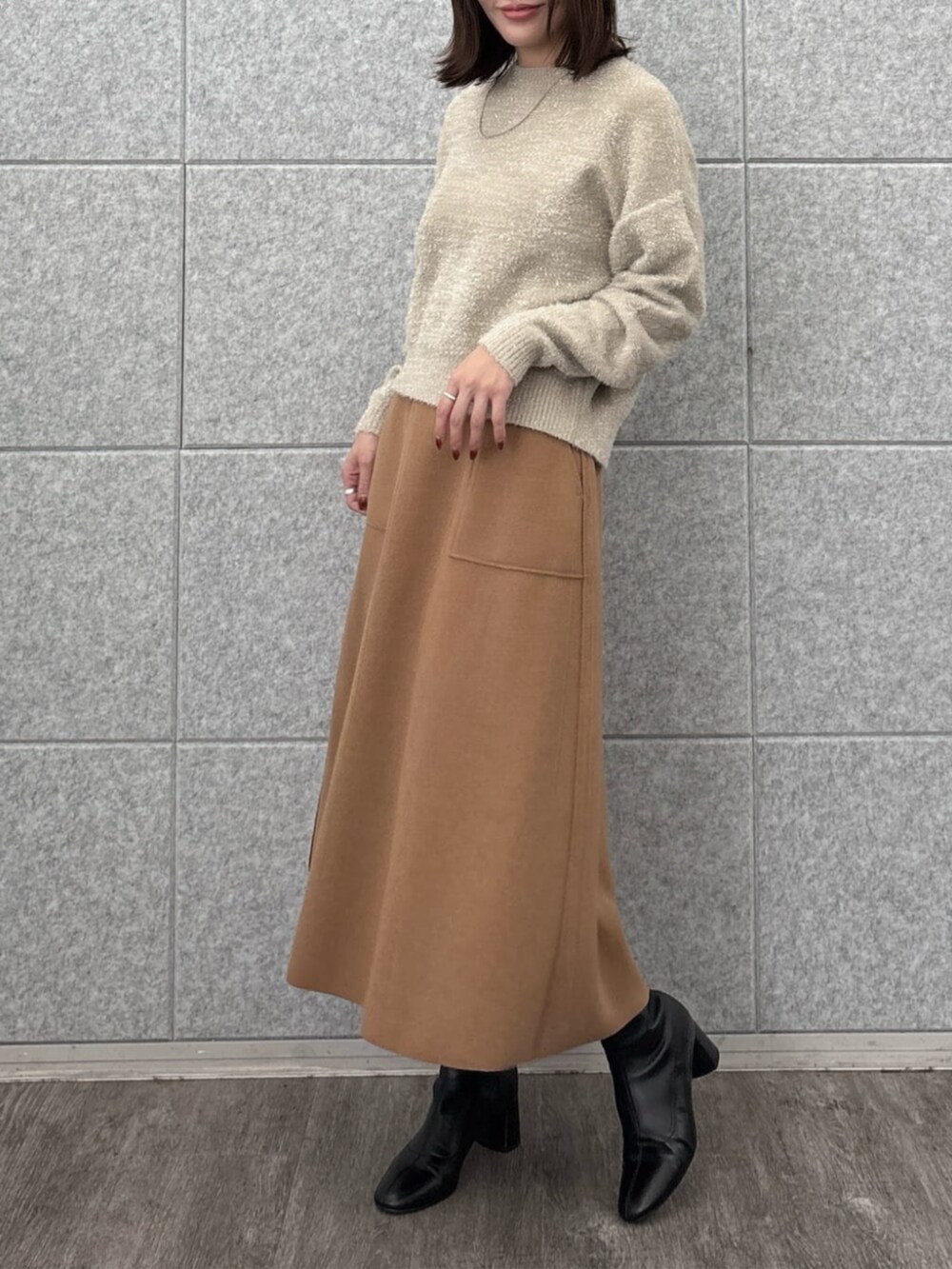 ベージュ系のニット/セーター、イエロー系のスカートを着用したレディースの秋コーディネートの5枚目の写真