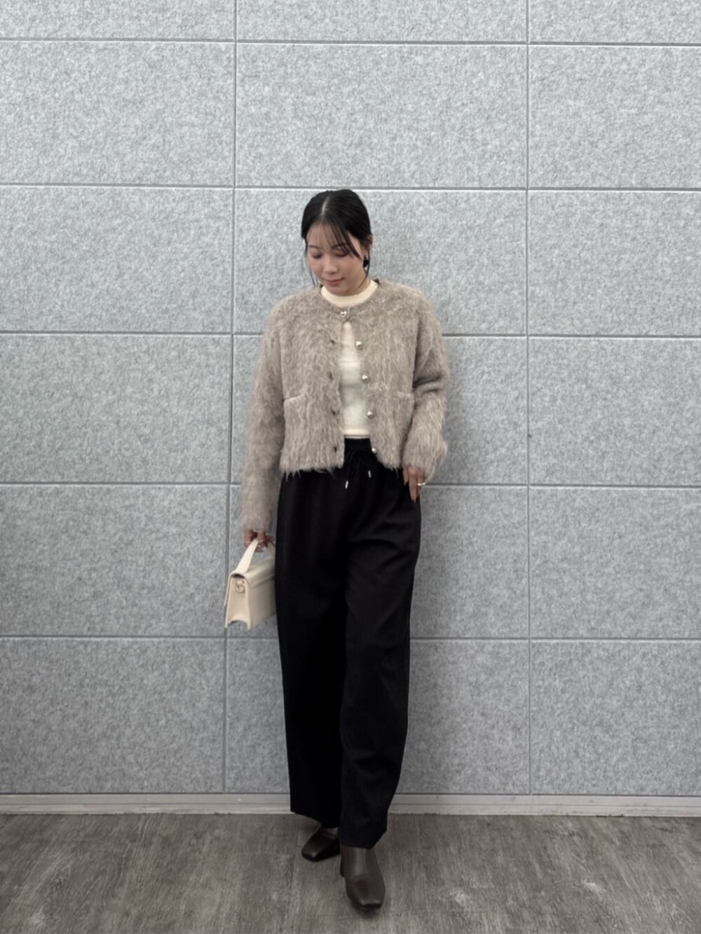 ブラック系のその他パンツ、ホワイト系のニット/セーター、ベージュ系のカーディガン/ボレロを着用したレディースの秋コーディネートの4枚目の写真