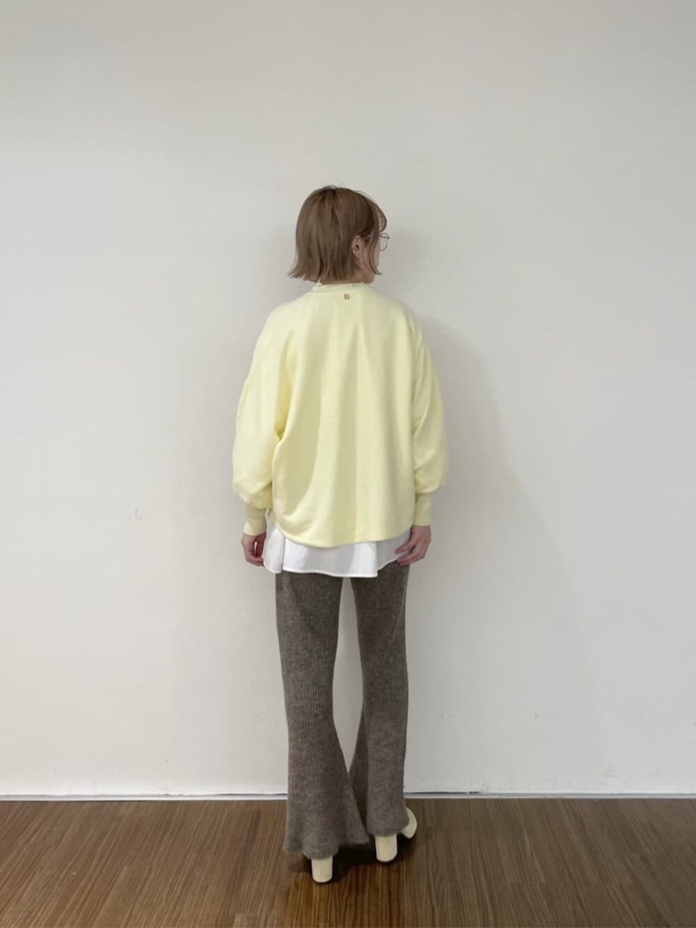 ホワイト系のシャツ/ブラウス、ブラウン系のその他パンツ、イエロー系のニット/セーターを着用したレディースの秋コーディネートの4枚目の写真