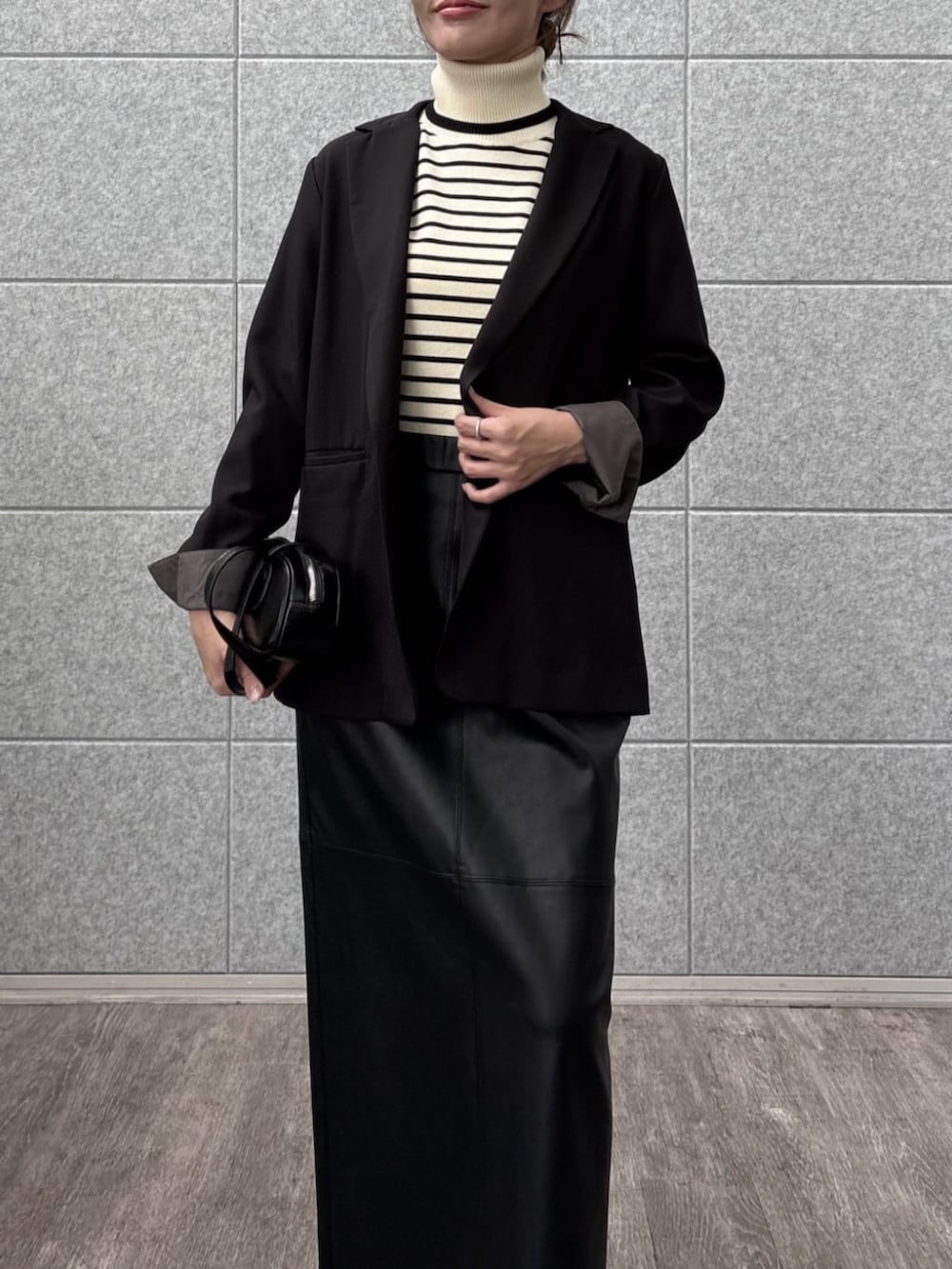 ブラック系のテーラードジャケット、ホワイト系のニット/セーターを着用したレディースの秋コーディネートの6枚目の写真