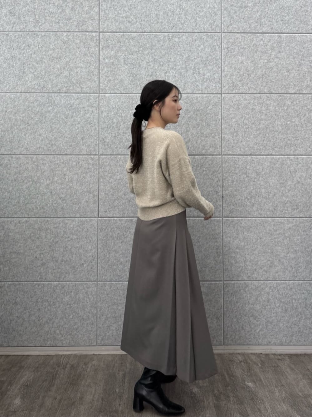 ベージュ系のニット/セーター、グレー系のスカートを着用したレディースの秋コーディネートの3枚目の写真