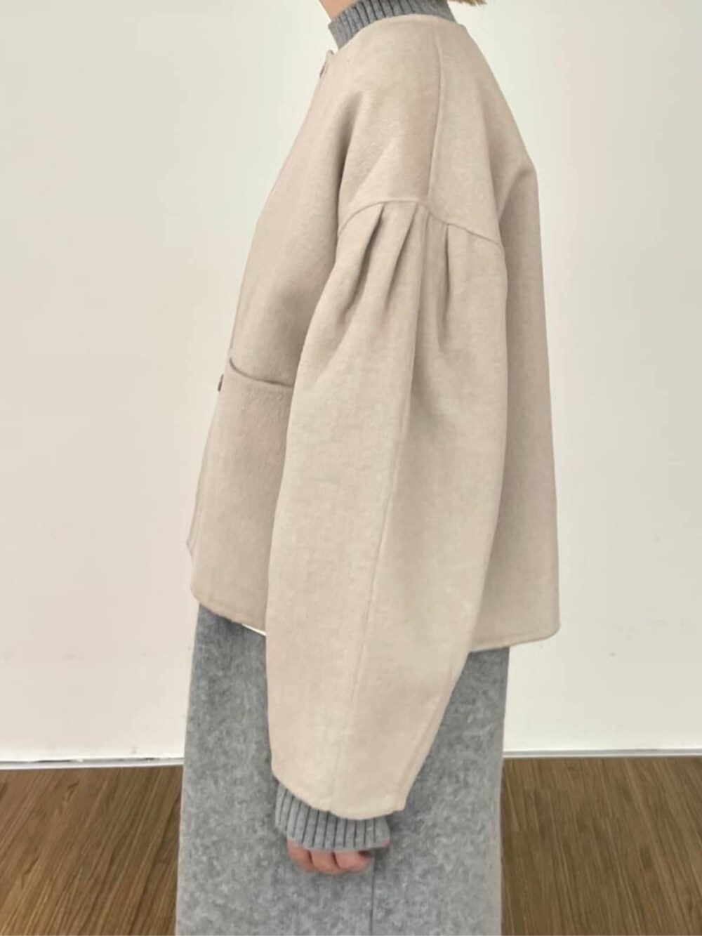 グレー系のワンピース、ベージュ系のノーカラーコートを着用したレディースの秋コーディネートの6枚目の写真