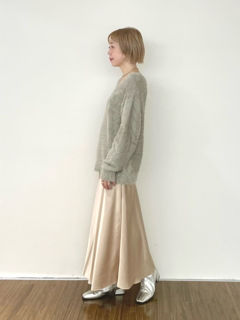 ベージュ系のスカート、グリーン系のニット/セーターを着用したレディースの冬コーディネートの4枚目の写真