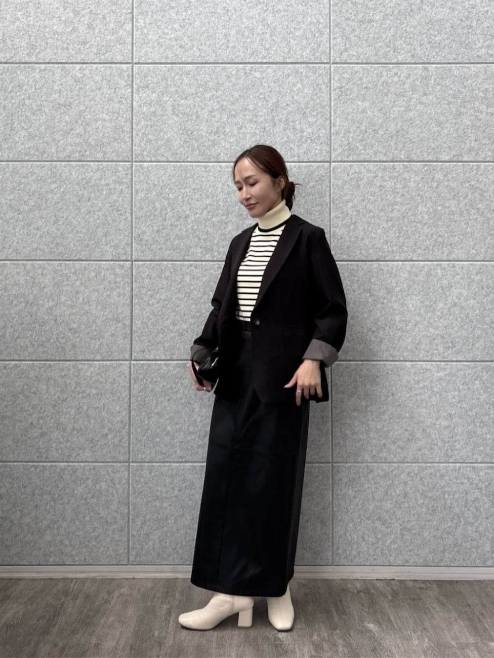 ブラック系のテーラードジャケット、ホワイト系のニット/セーターを着用したレディースの秋コーディネートの3枚目の写真