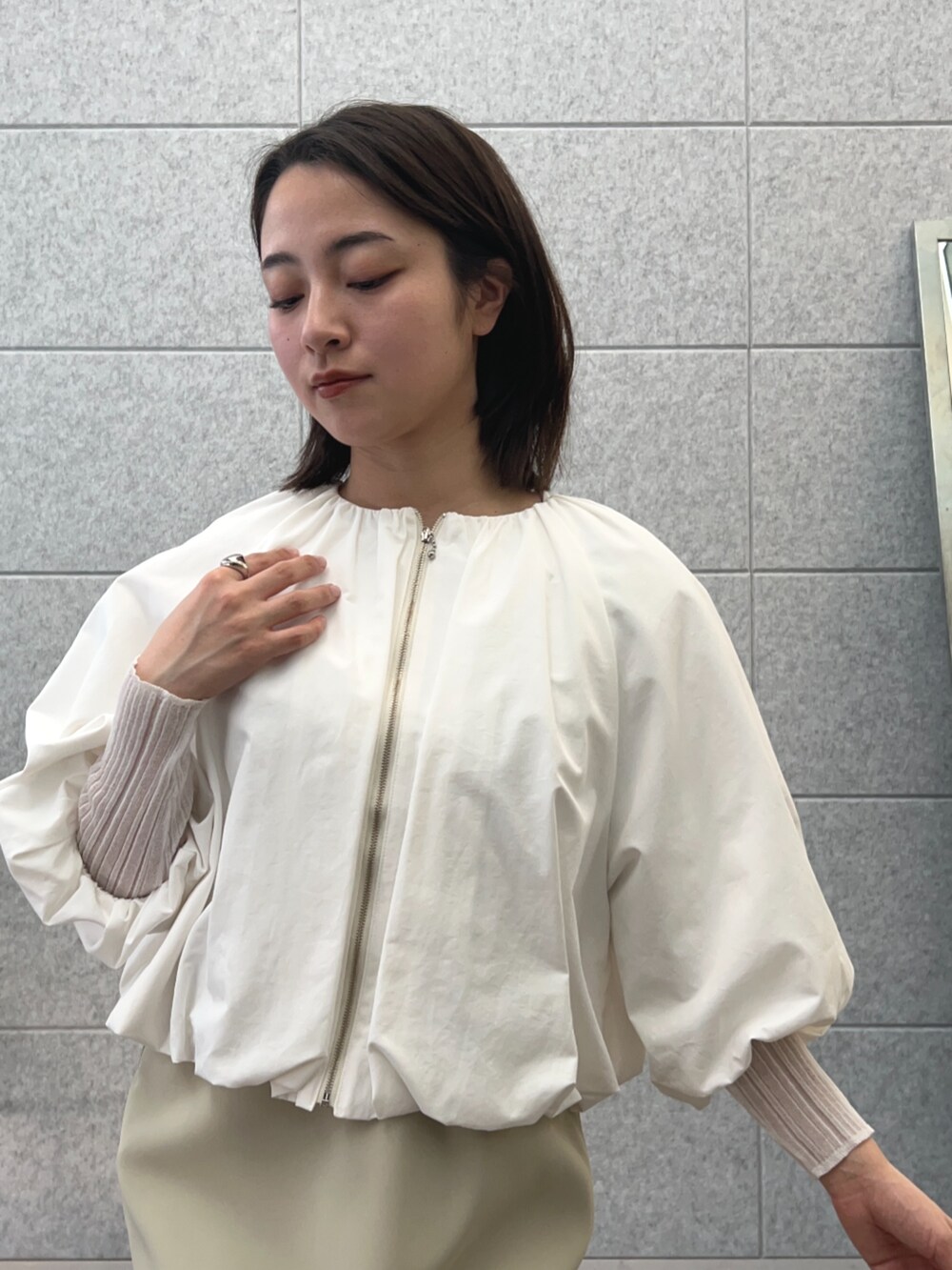 ホワイト系のTシャツ/カットソー、ベージュ系のワンピース、ホワイト系のブルゾンを着用したレディースの春コーディネートの7枚目の写真