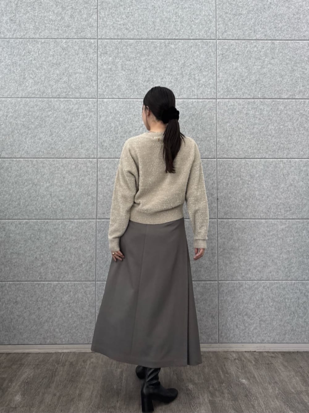 ベージュ系のニット/セーター、グレー系のスカートを着用したレディースの秋コーディネートの4枚目の写真
