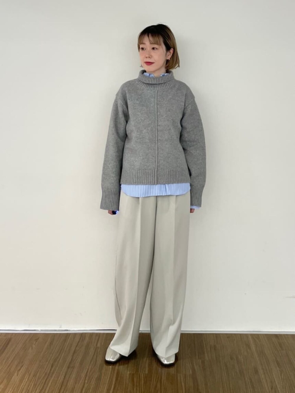 ベージュ系のその他パンツ、グレー系のニット/セーター、ブルー系のシャツ/ブラウスを着用したレディースの秋コーディネートの2枚目の写真