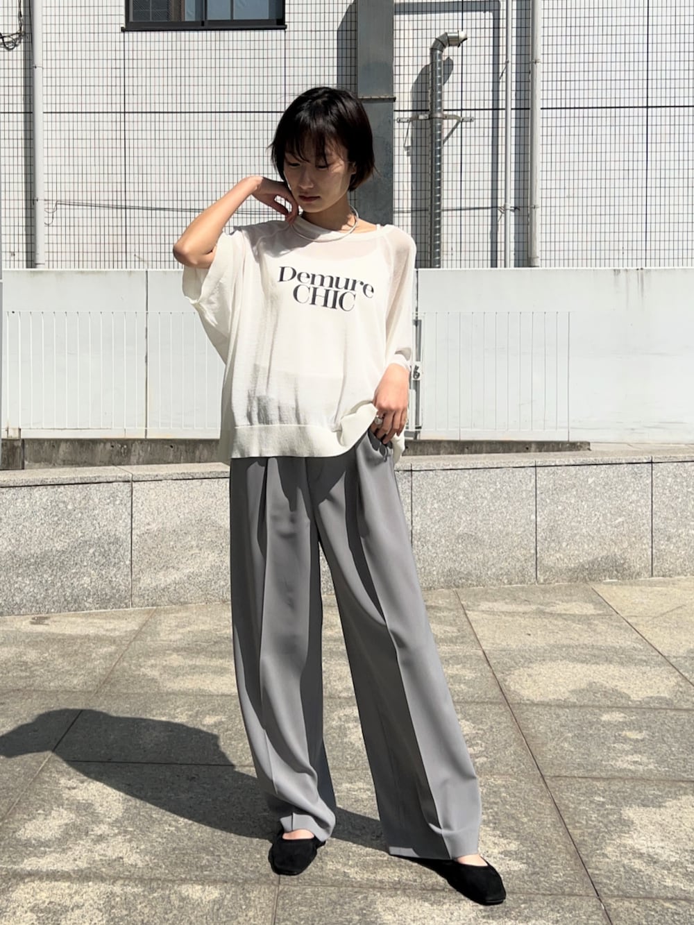 グレー系のその他パンツ、ホワイト系のニット/セーターを着用したレディースの春コーディネートの2枚目の写真