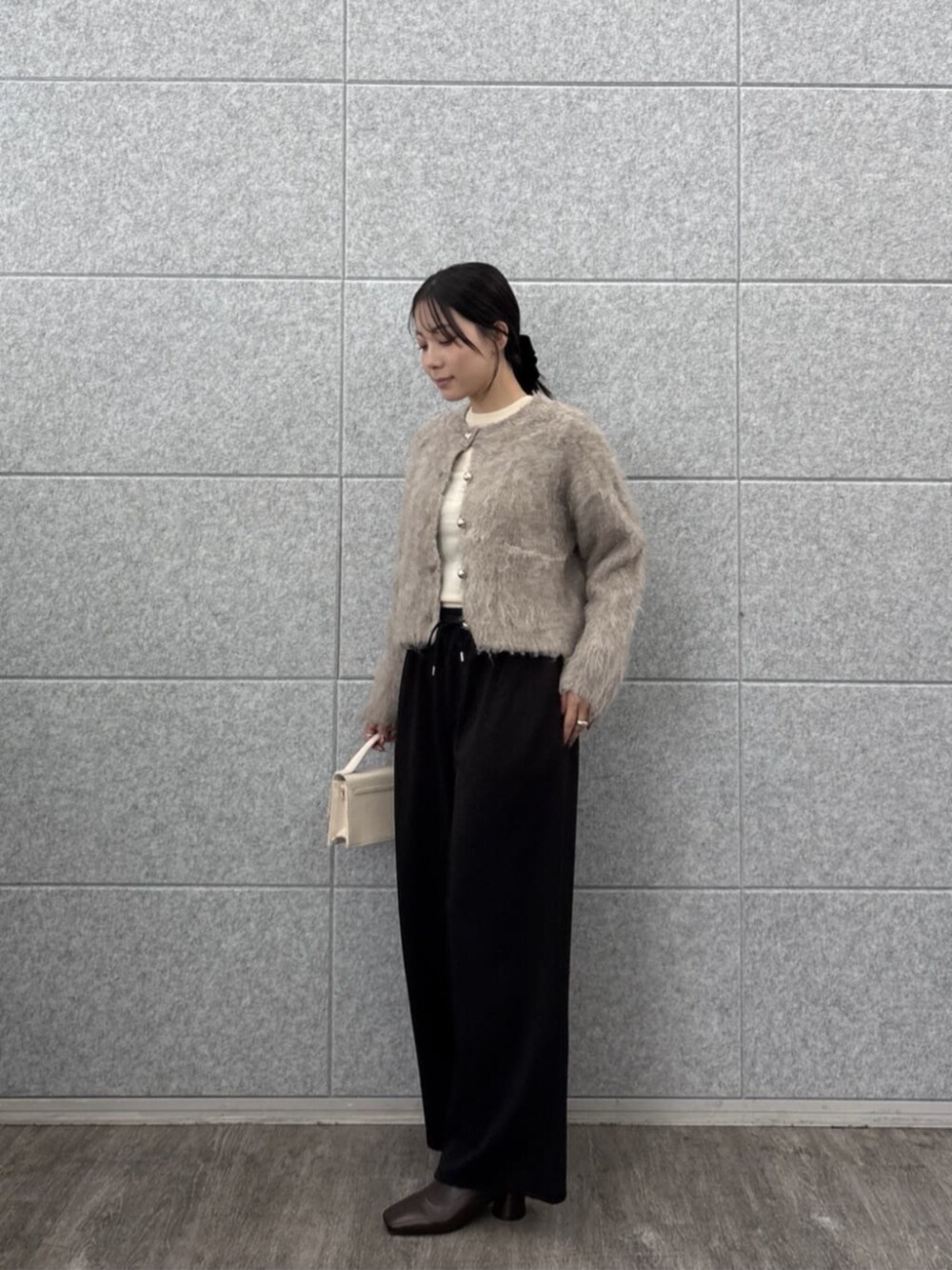 ブラック系のその他パンツ、ホワイト系のニット/セーター、ベージュ系のカーディガン/ボレロを着用したレディースの秋コーディネートの5枚目の写真