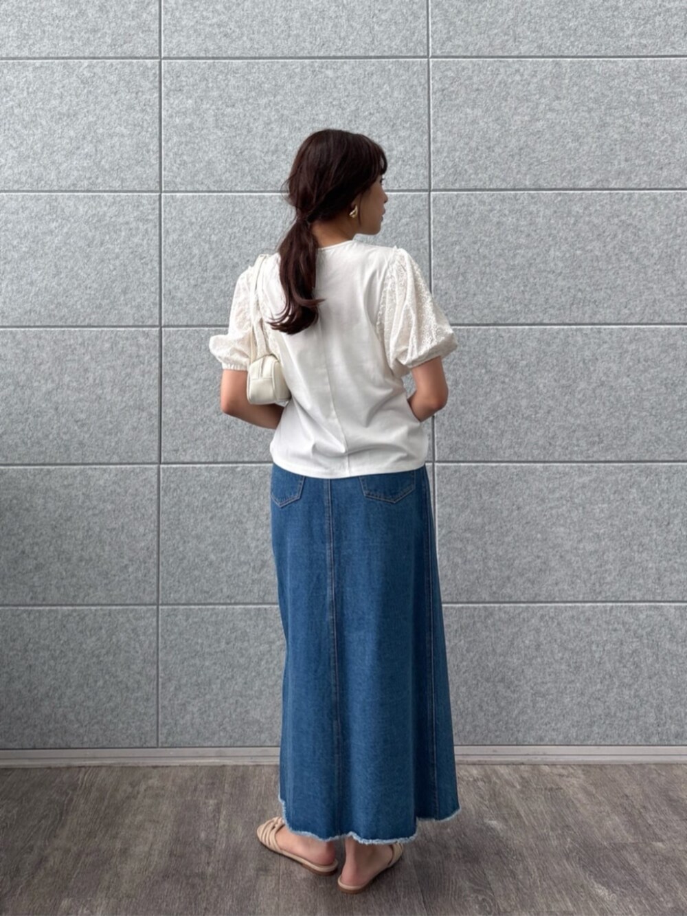 ブルー系のデニムスカート、ホワイト系のTシャツ/カットソーを着用したレディースの夏コーディネートの2枚目の写真