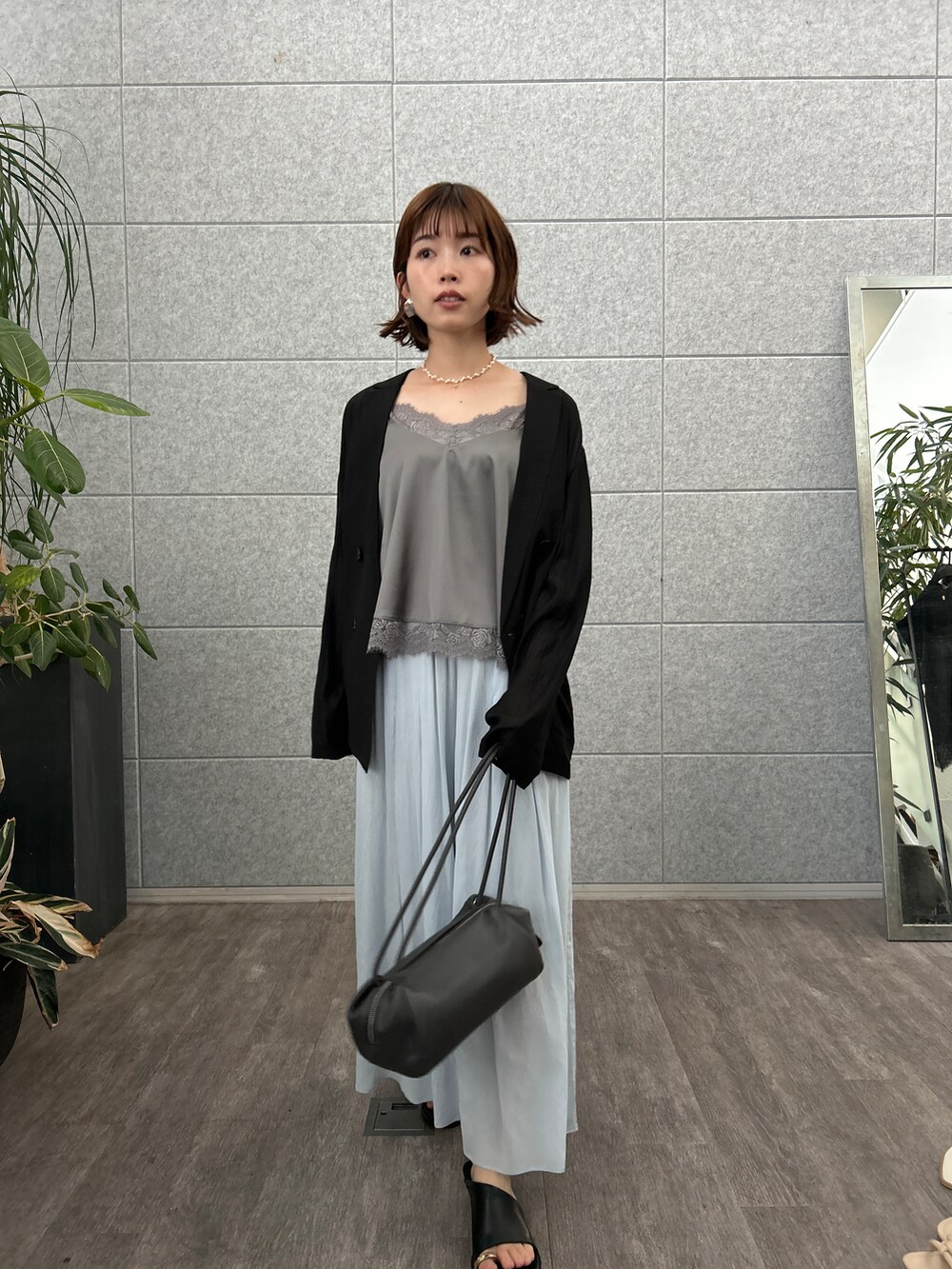 グレー系のタンクトップ、ブラック系のテーラードジャケット、ブルー系のその他パンツを着用したレディースの夏コーディネートの2枚目の写真