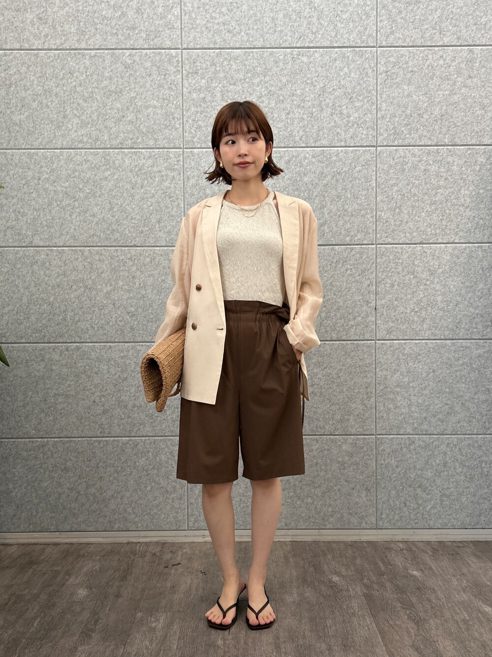 ピンク系のテーラードジャケット、ブラウン系のその他パンツを着用したレディースの夏コーディネートの3枚目の写真