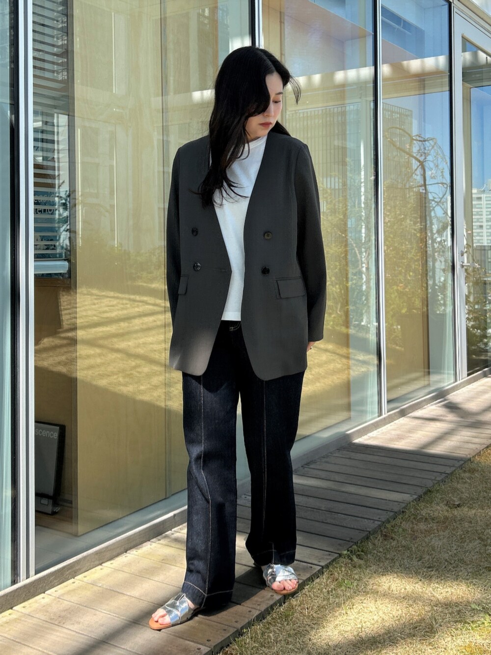 ブルー系のデニムパンツ、グレー系のノーカラージャケットを着用したレディースの春コーディネートの2枚目の写真
