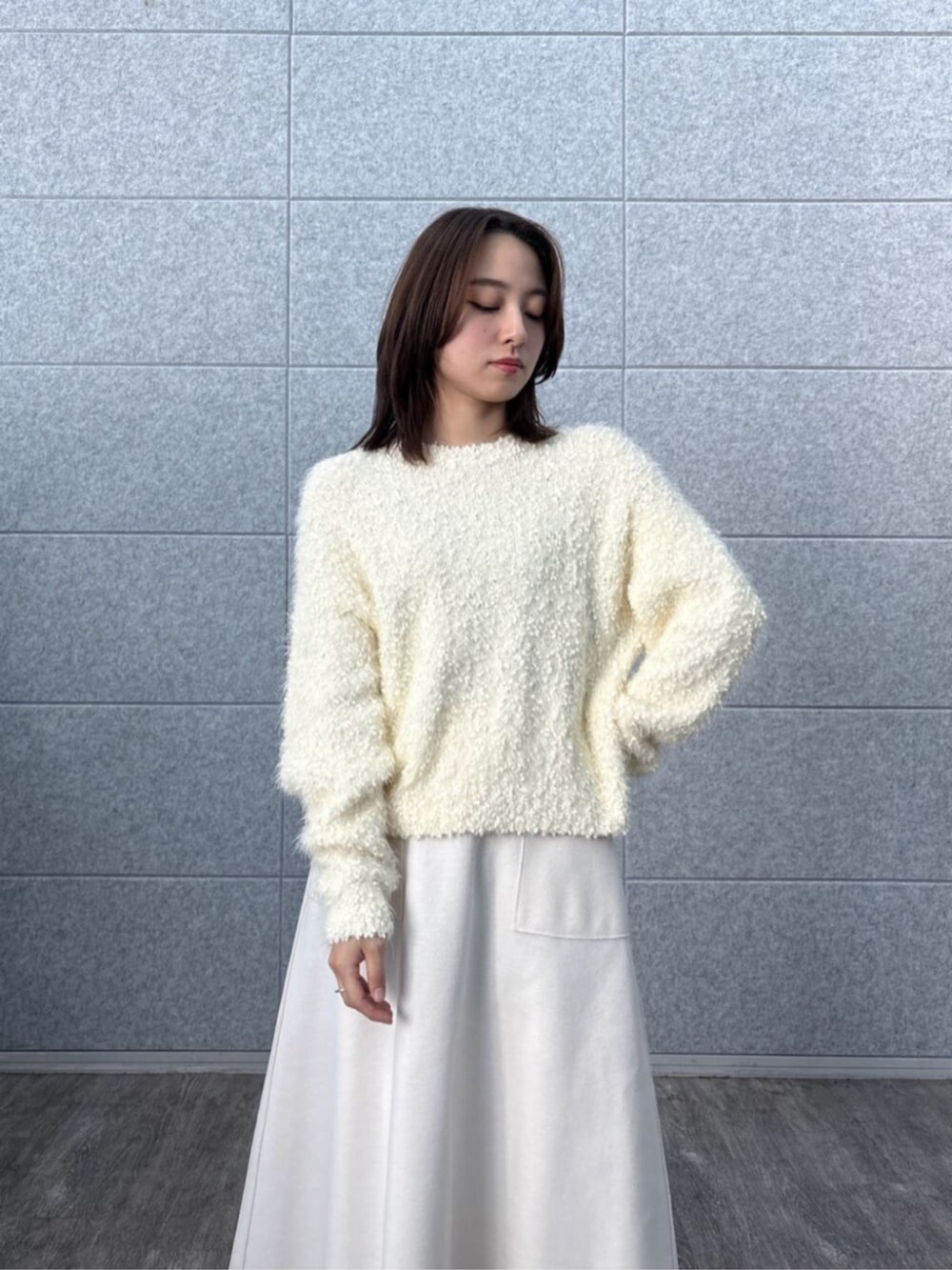 ホワイト系のニット/セーター、ホワイト系のスカートを着用したレディースの冬コーディネートの7枚目の写真