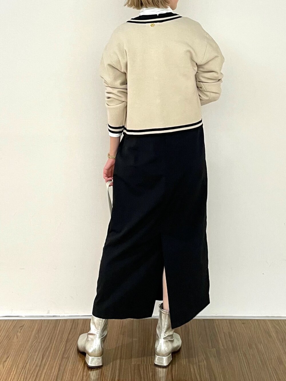 ブラック系のワンピース、ホワイト系のTシャツ/カットソー、ベージュ系のカーディガン/ボレロを着用したレディースの秋コーディネートの4枚目の写真