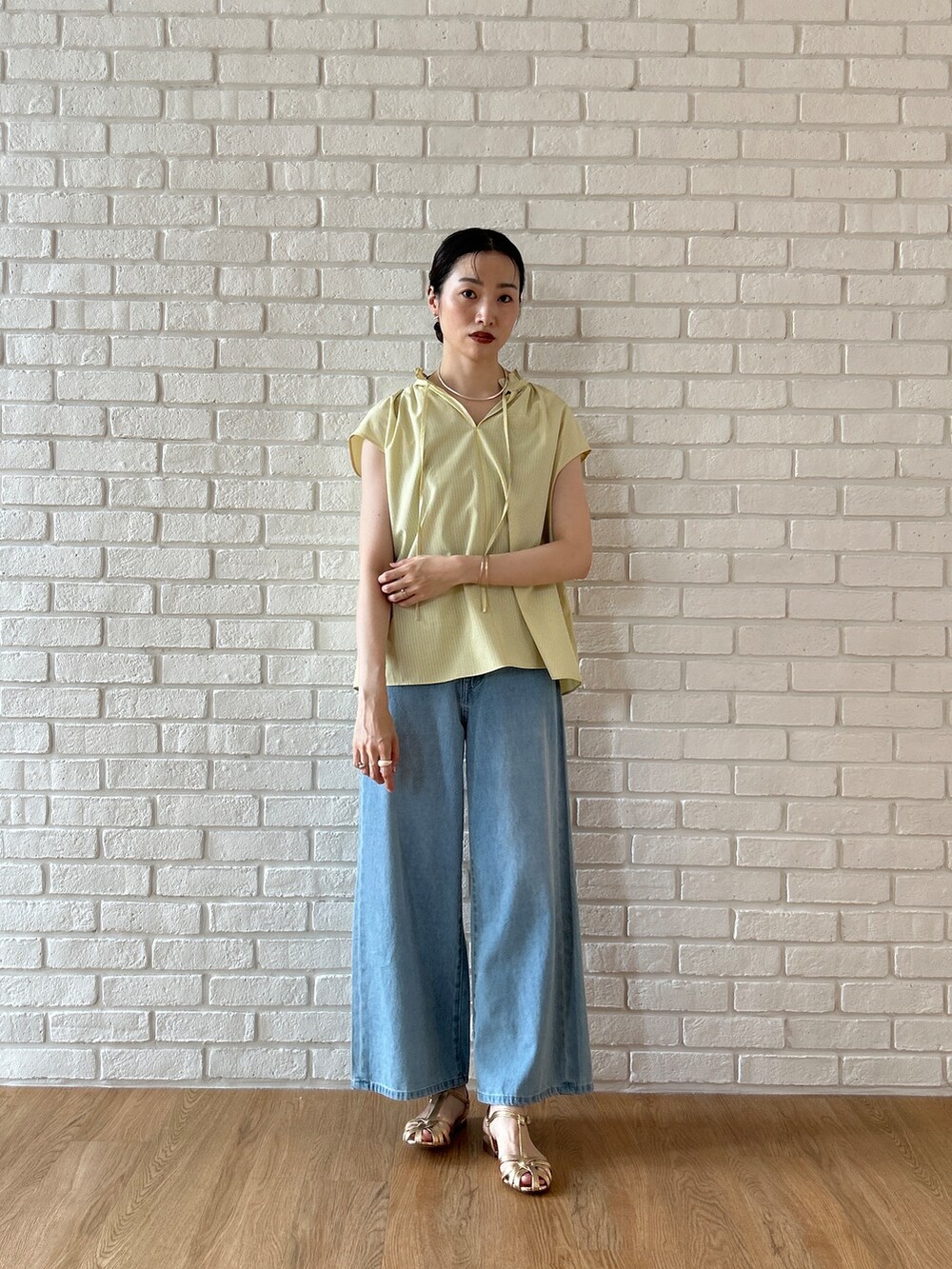 ブルー系のデニムパンツを着用したレディースの春コーディネートの2枚目の写真
