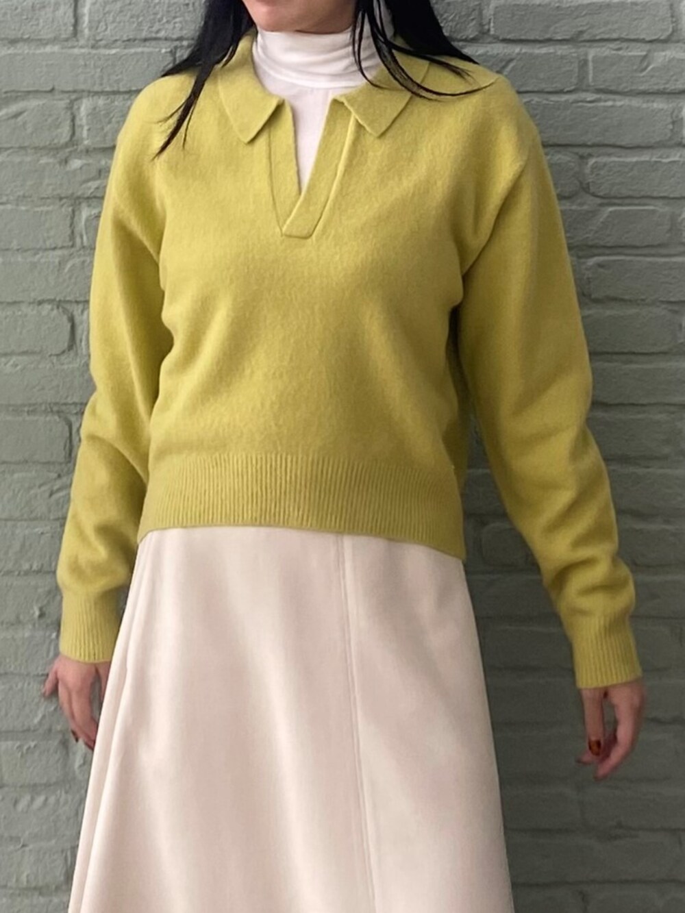 ホワイト系のTシャツ/カットソー、ホワイト系のスカート、イエロー系のニット/セーターを着用したレディースの秋コーディネートの5枚目の写真