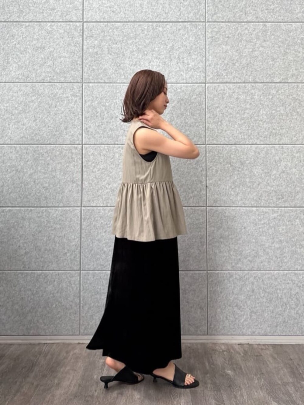 グリーン系のベストを着用したレディースの秋コーディネートの5枚目の写真