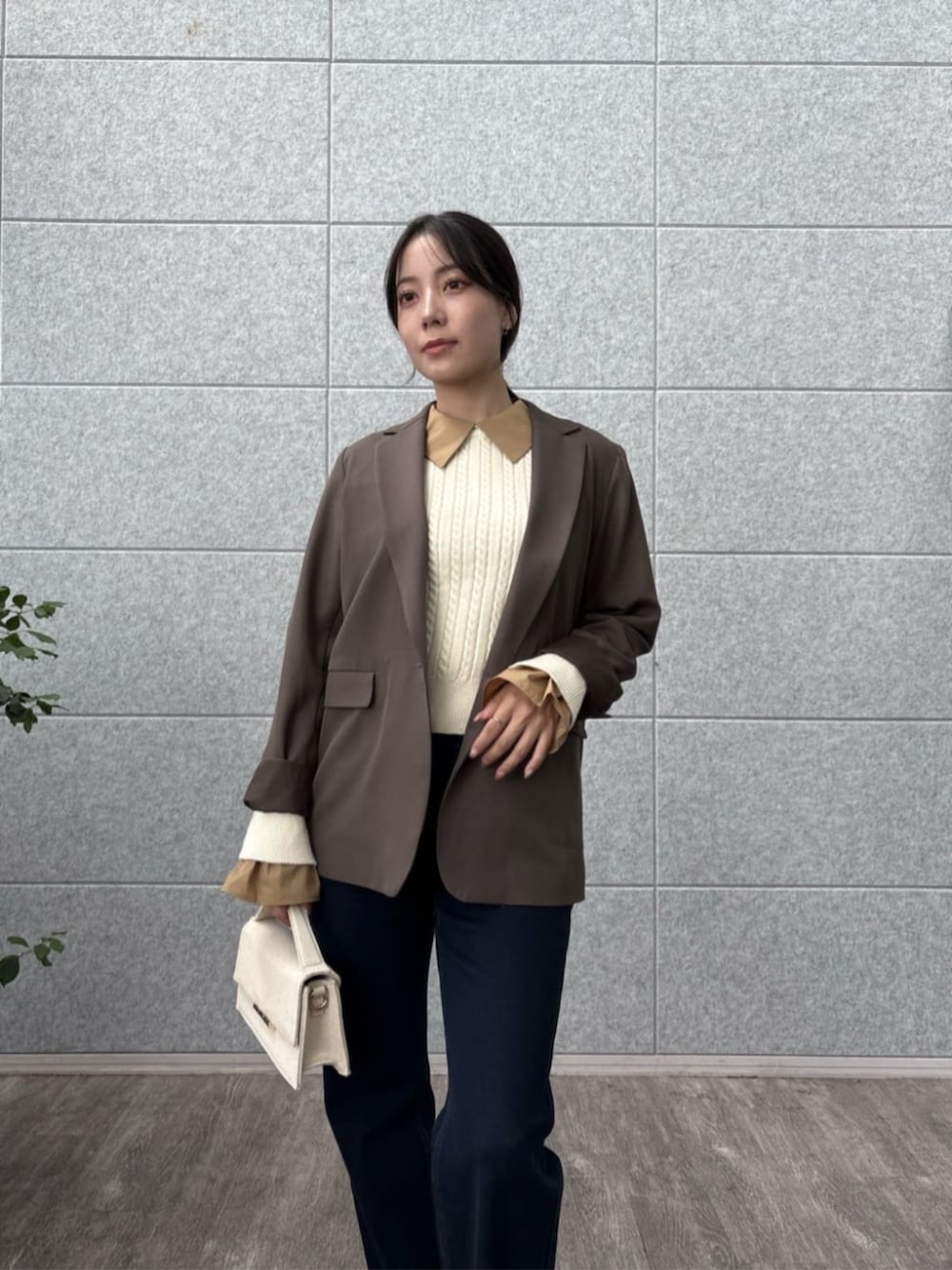 ブラウン系のテーラードジャケット、ブルー系のデニムパンツ、ホワイト系のニット/セーターを着用したレディースの秋コーディネートの7枚目の写真