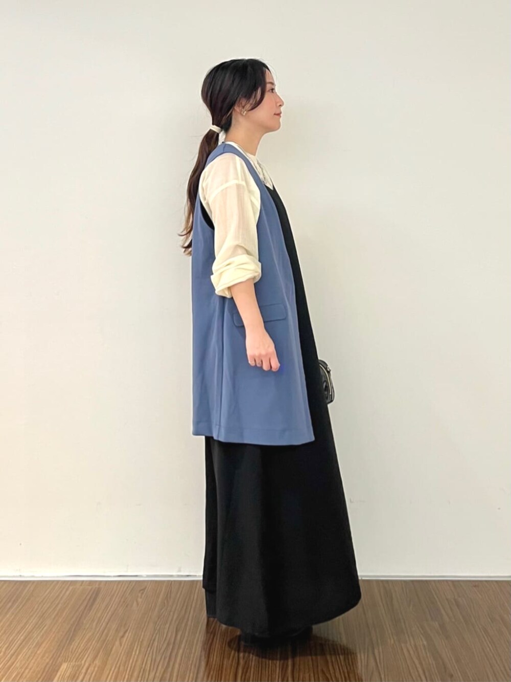 ブラック系のワンピース、ブルー系のベスト、ホワイト系のシャツ/ブラウスを着用したレディースの秋コーディネートの3枚目の写真