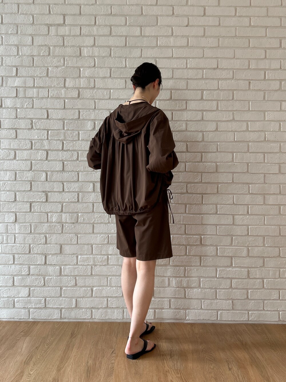 ブラウン系のブルゾン、ブラック系のタンクトップ、ブラウン系のその他パンツを着用したレディースの春コーディネートの4枚目の写真
