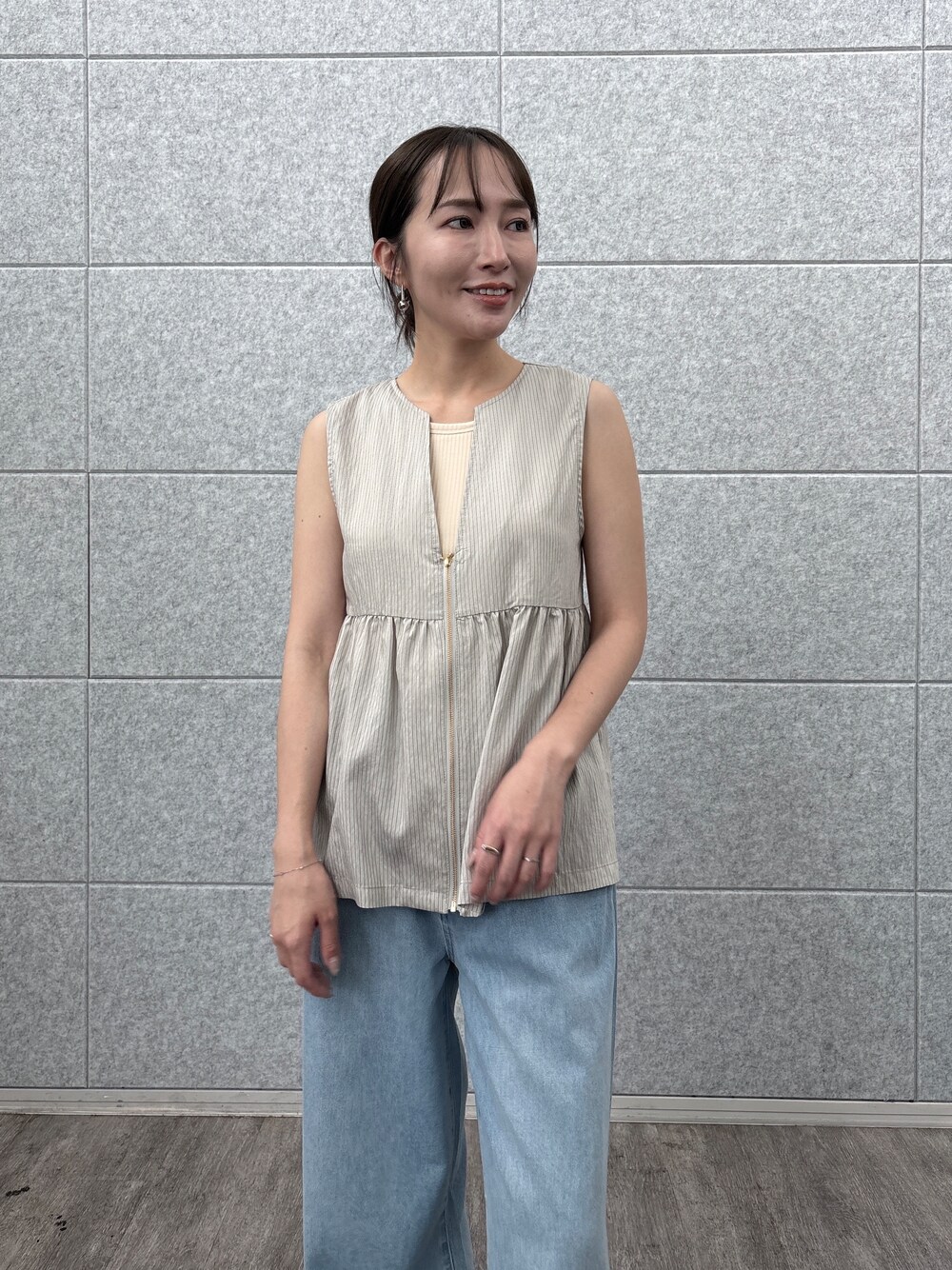 ベージュ系のシャツ/ブラウス、ブルー系のデニムパンツを着用したレディースの夏コーディネートの6枚目の写真
