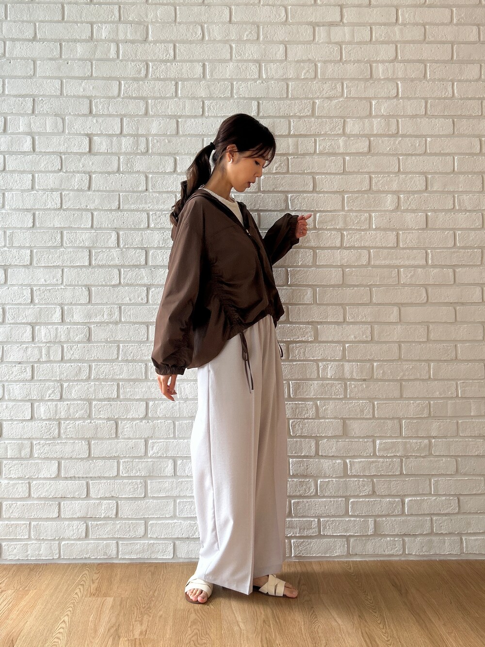 ブラウン系のブルゾン、ベージュ系のタンクトップ、グレー系のその他パンツを着用したレディースの夏コーディネートの4枚目の写真