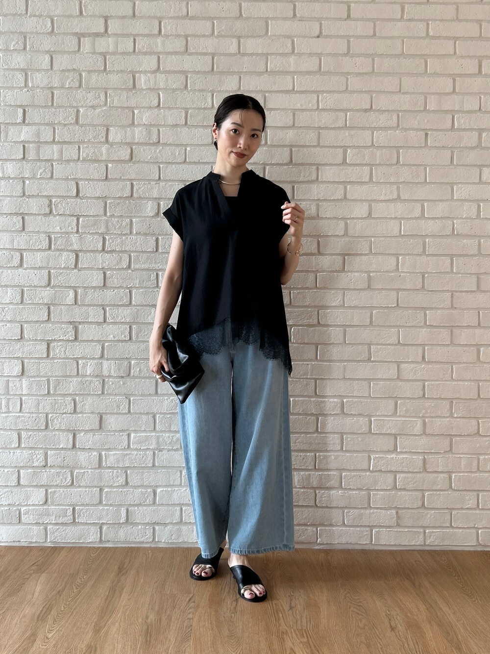 ブラック系のシャツ/ブラウス、ブルー系のデニムパンツを着用したレディースの春コーディネートの7枚目の写真