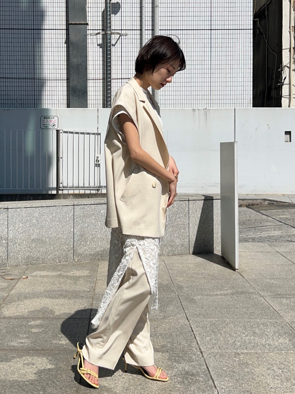 ホワイト系のタンクトップ、ホワイト系のテーラードジャケット、ホワイト系のワンピースを着用したレディースの春コーディネートの5枚目の写真