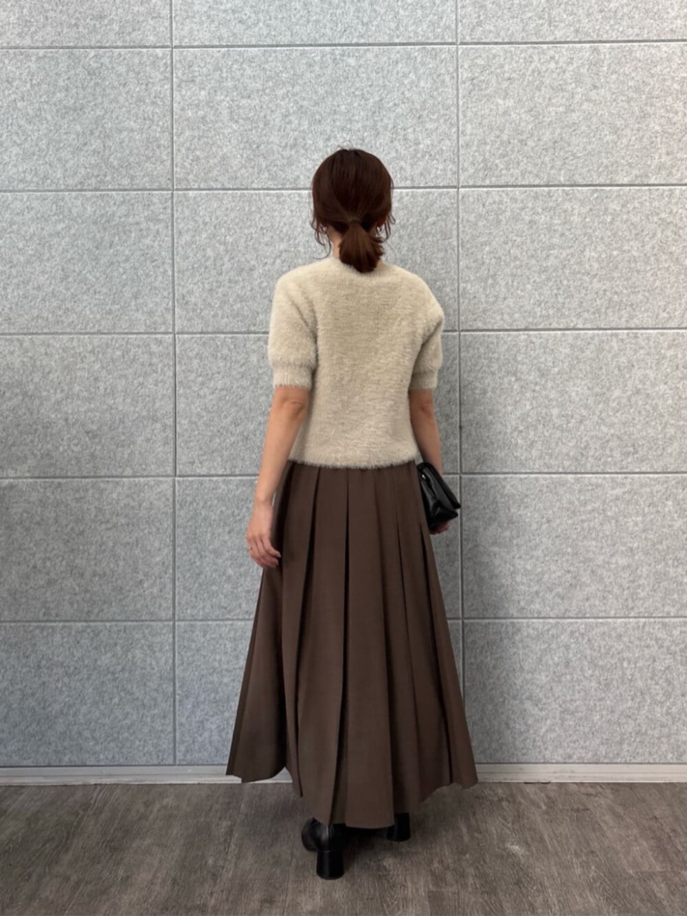 ベージュ系のニット/セーター、ブラウン系のスカートを着用したレディースの秋コーディネートの4枚目の写真