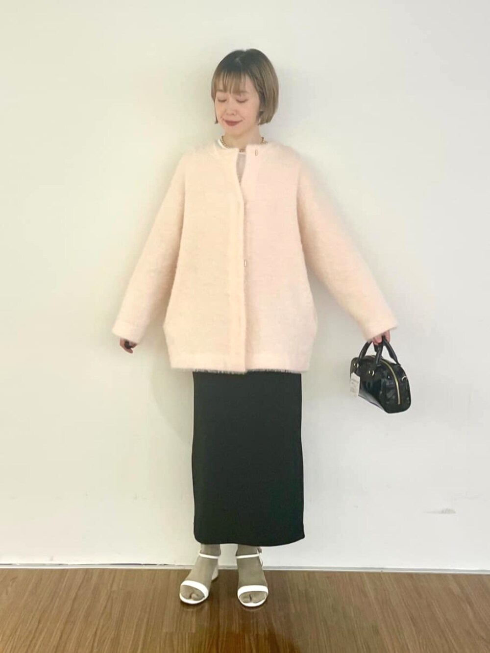 ピンク系のカーディガン/ボレロ、ブラック系のスカート、ホワイト系のTシャツ/カットソーを着用したレディースの秋コーディネートの5枚目の写真