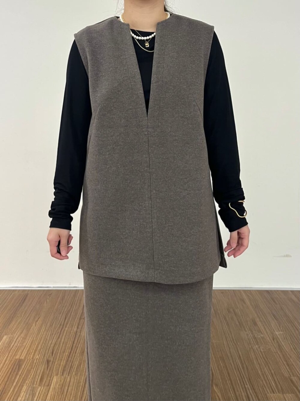 ブラウン系のベスト、ブラウン系のスカート、ブラック系のTシャツ/カットソーを着用したレディースの秋コーディネートの6枚目の写真