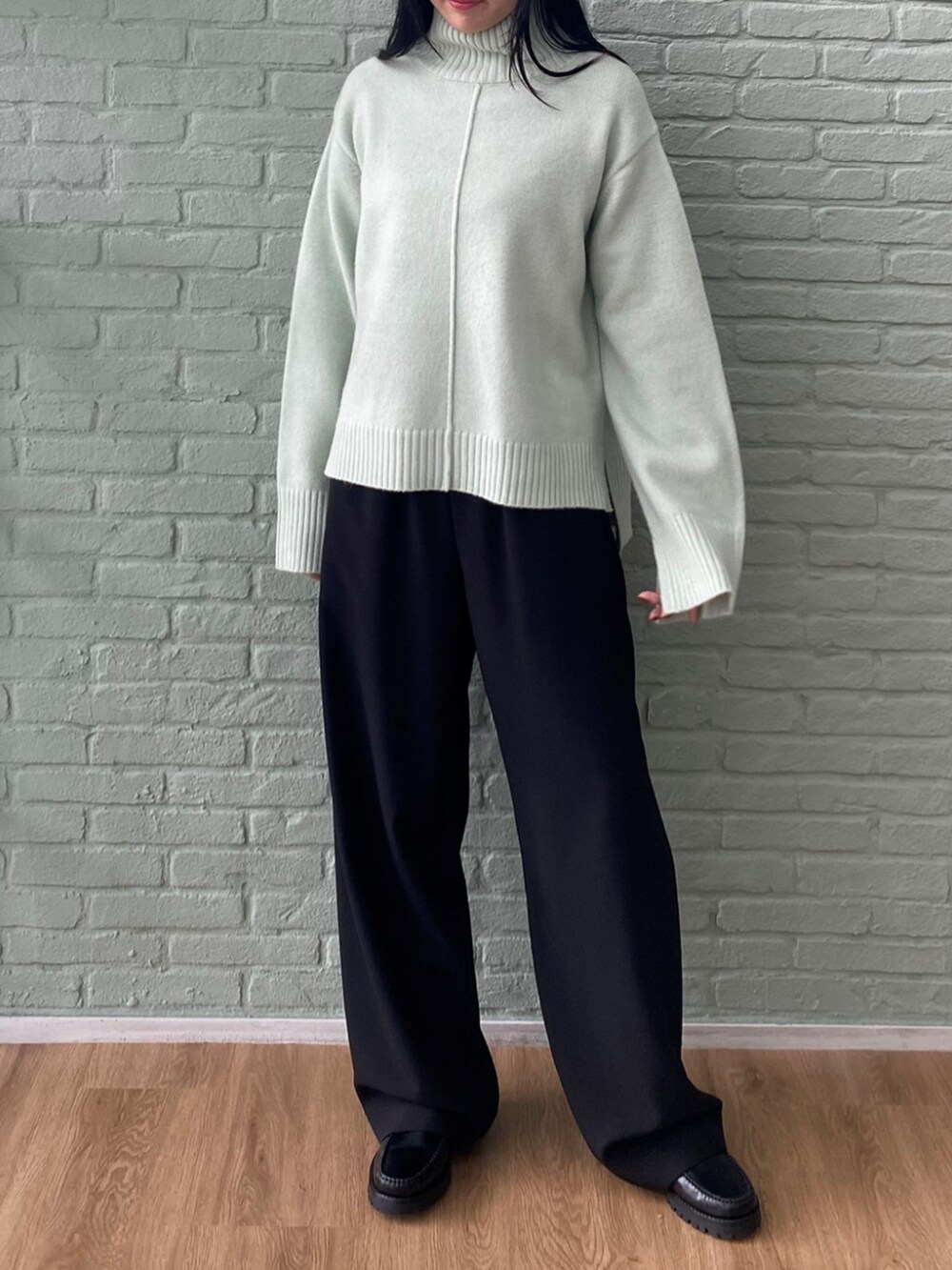 ブラック系のその他パンツ、グリーン系のニット/セーターを着用したレディースの秋コーディネートの2枚目の写真