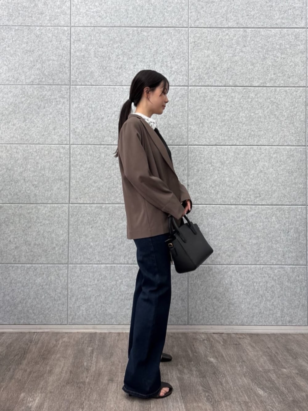 ブラウン系のテーラードジャケット、ブラック系のTシャツ/カットソー、ブルー系のデニムパンツを着用したレディースの秋コーディネートの5枚目の写真